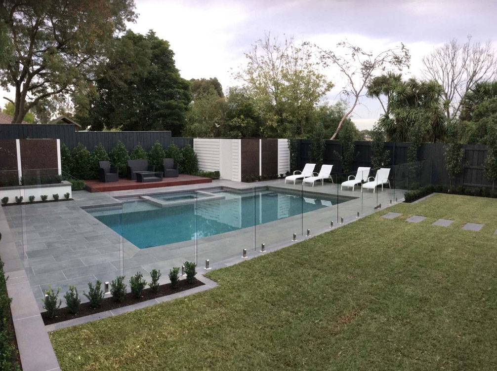 Crystal blue swimming pool finished with light grey porcelain mosaic tiles.