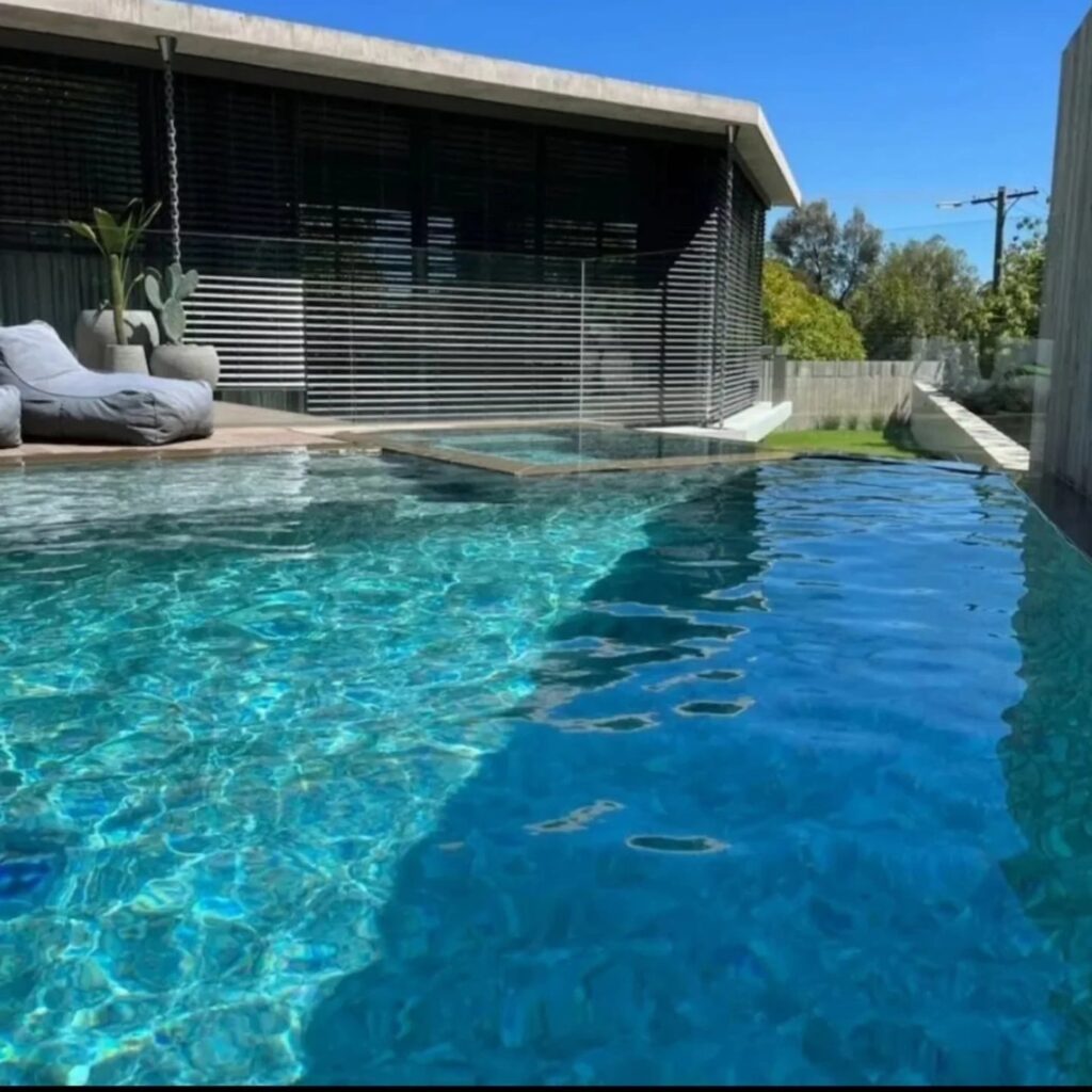 Luxury swimming pool in Ivanhoe featuring textured porcelain Sukabumi look pool tiles